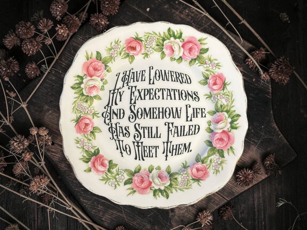 Vintage decorative plate reading I Have Lowered My Expectations and Somehow Life Has Still Failed to Meet Them