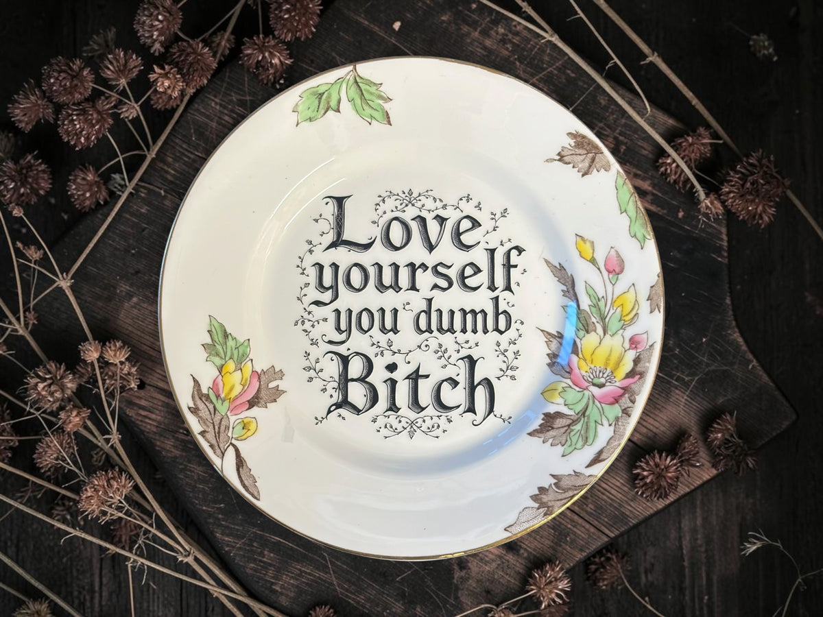 Vintage decorative plate reading Love Yourself You Dumb Bitch