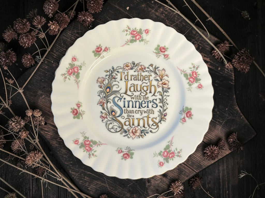 Vintage decorative plate reading I’d Rather Laugh with the Sinners Than Cry with the Saints