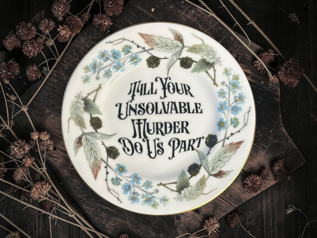 Vintage decorative plate reading Till Your Unsolvable Murder Do Us Part