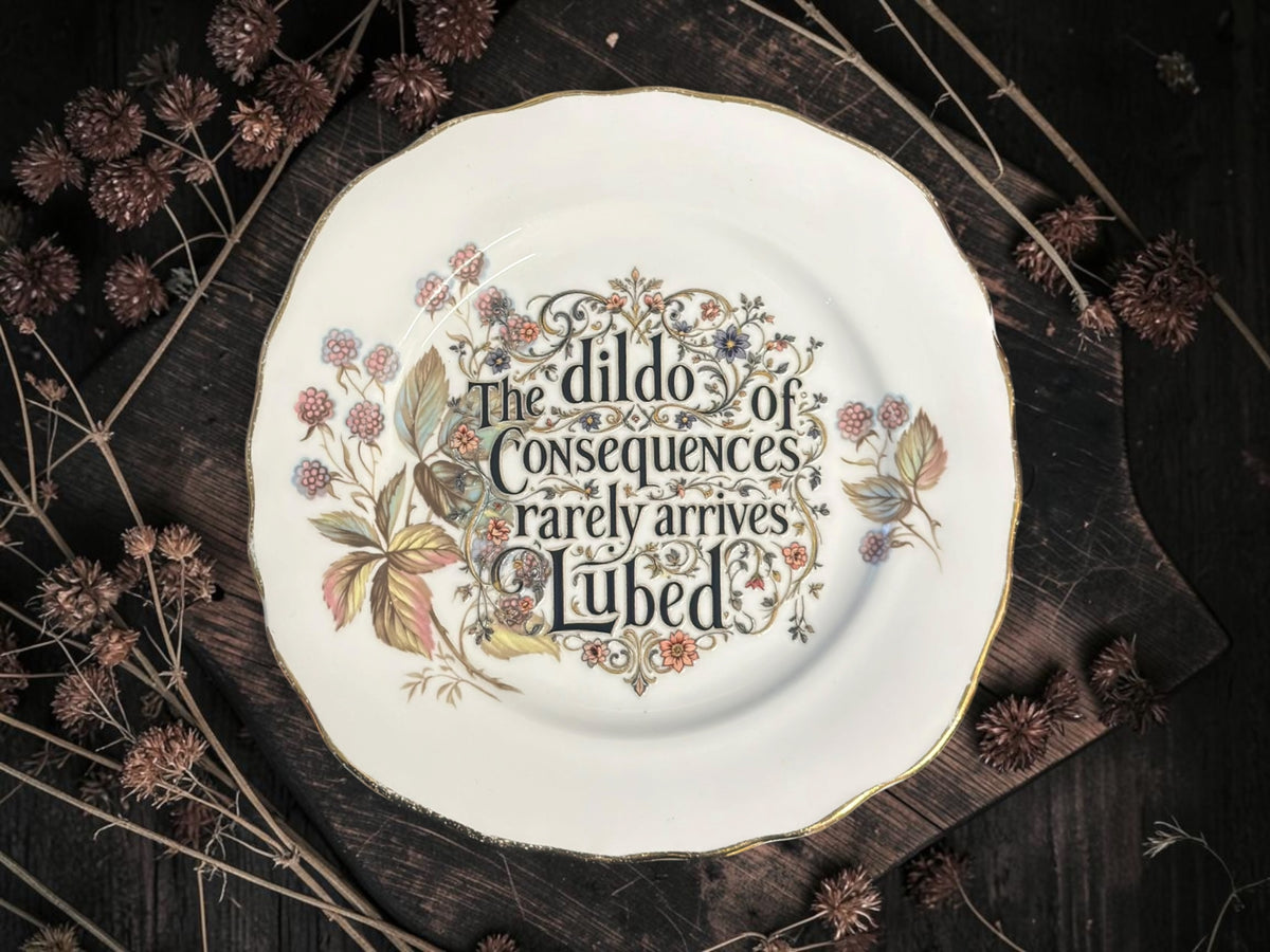 Vintage decorative plate featuring The Dildo of Consequences Rarely Arrives Lubed