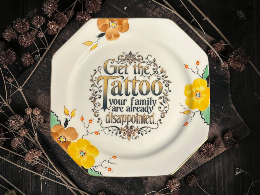 Vintage decorative plate reading Get the tattoo, your family are already disappointed