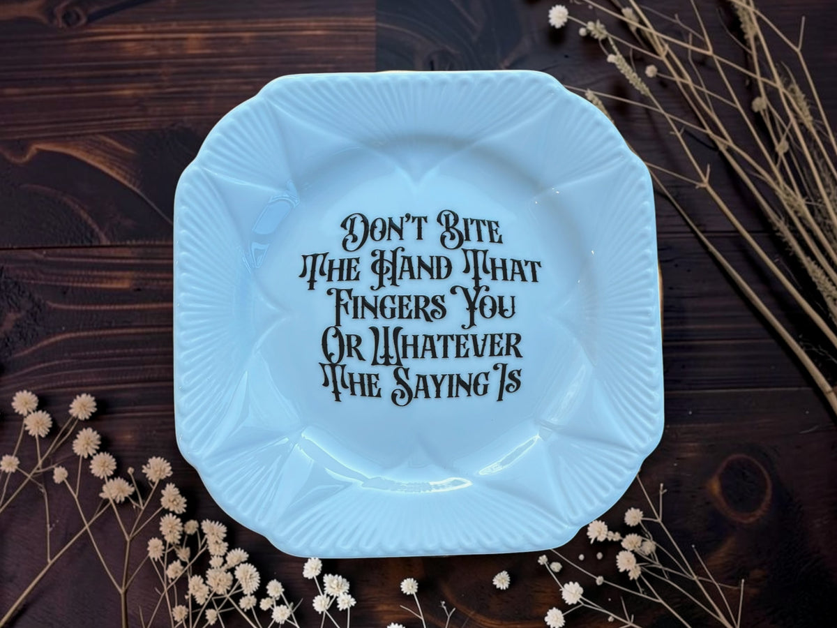 Square vintage plate reading Don't Bite The Hand That Fingers You Or Whatever The Saying Is